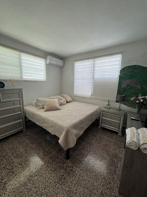 A bedroom with a bed, dresser, nightstands, and a window with blinds. - Isla del Encanto 3BR/2BA Lux Retreat in San Juan. 8min to SJU (San Juan)