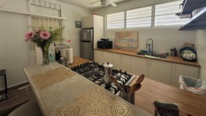 Eine moderne Küche mit Gasherd, Kühlschrank und Deckenventilator.