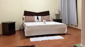 Une chambre bien rangée, avec un lit, une table de chevet et une chaise.