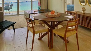 Comedor con vista al mar, ventilador de techo y un espejo grande.