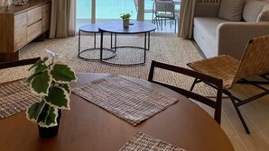 A modern living room with a large window, a ceiling fan, a dining area with a table and chairs, and a sofa. - Stunning Beachfront Property (Crucecita)