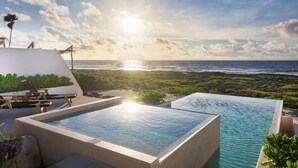A pool with a view of the ocean and beach at sunset. - Valina (Tulsayab)