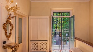 A hallway with a white door, a bench, and a patterned rug. - Villa Cecilia, facing Lucca's ancient city walls! (Lucca)