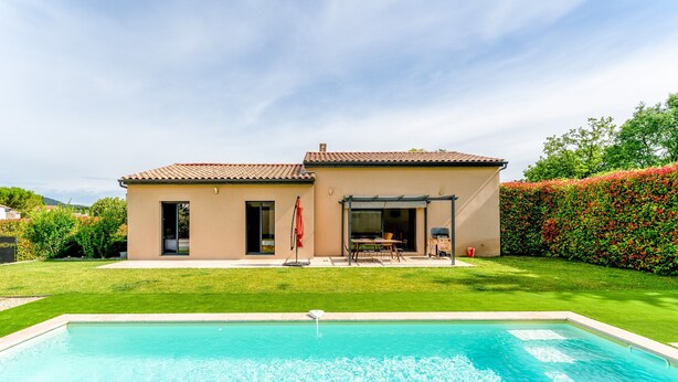 A house with a swimming pool, a patio, and a garden.