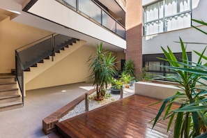 A multi-level interior with a staircase, potted plants, and a wooden deck area. - Central Apartment in Seville with Wi-Fi, Air Conditioning, and Optional Parking (Sevilla)