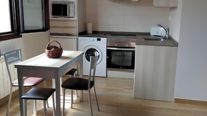 Una cocina moderna con comedor, que incluye una mesa, sillas y un microondas.