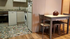 Una cocina compacta equipada con lavadora, microondas y lavavajillas.