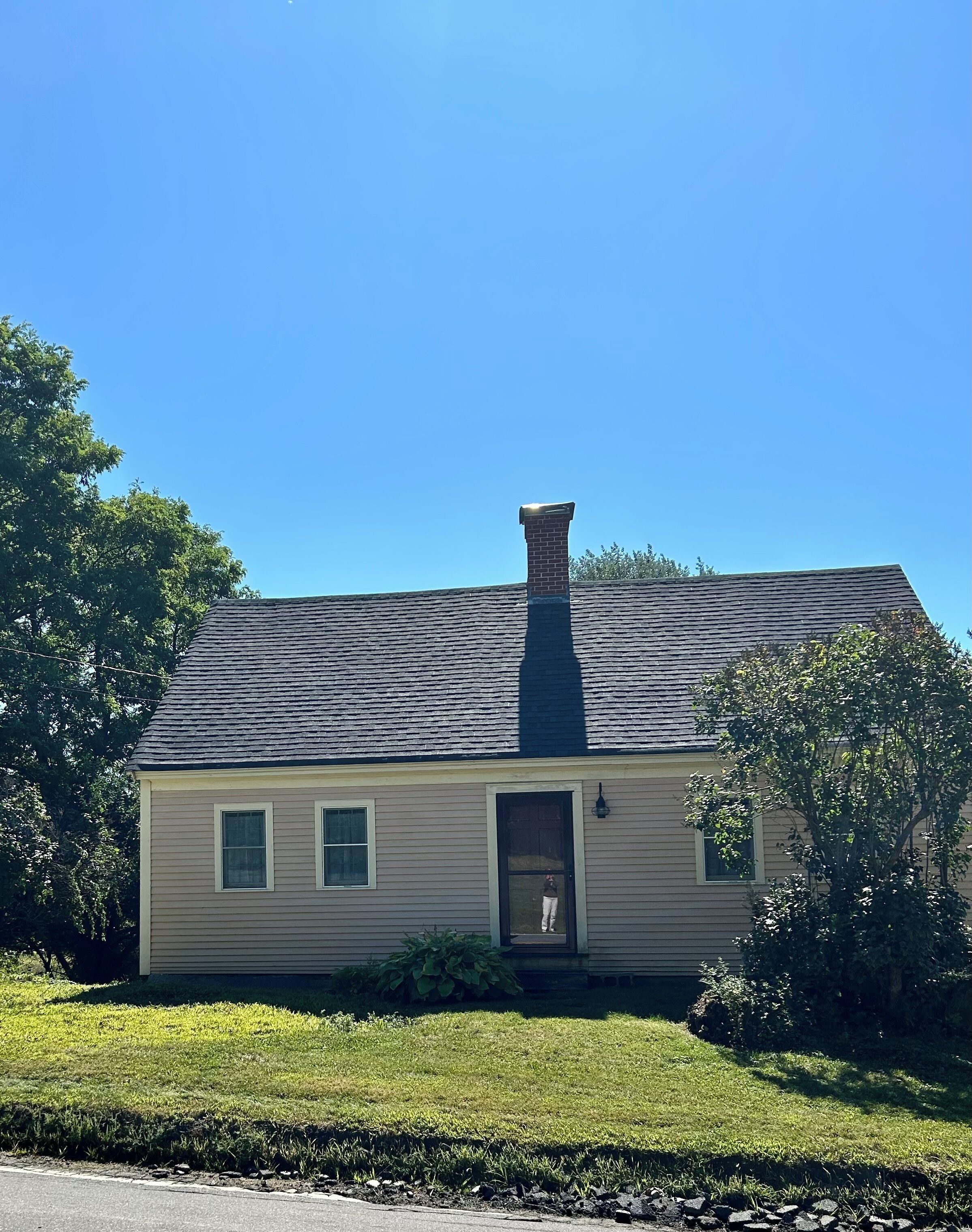 A single-story house with a chimney, a front door, and a small porch area.
