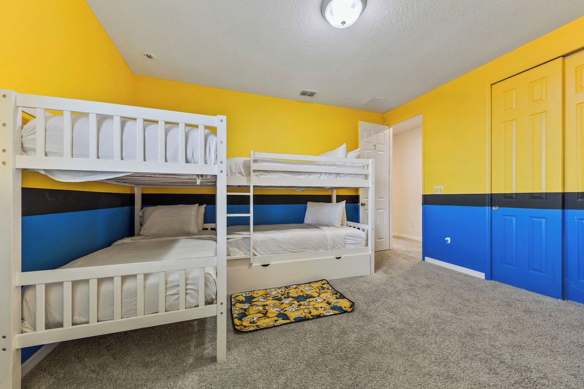 A room with bunk beds, a door, and a carpet.