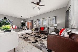 Ein modernes Wohnzimmer mit einer Couch, einem Couchtisch und einem Deckenventilator.