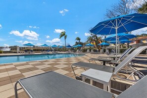 Ein Poolbereich mit Liegestühlen und Sonnenschirmen.