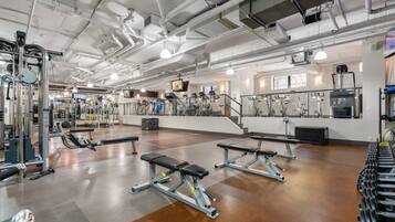 A gym with various exercise equipment, including treadmills, stationary bikes, and weight machines.