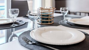 A dining table set with white plates, black placemats, and clear glassware. - Appartement calme et lumineux, terrasse et P privé (Balma)