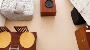 A living room with a sofa, a coffee table, a dining table, and a white railing. - LVAM - Appartement Résidence St Clair - Piscine - 4 personnes - Cap d'Agde (Le Cap D'Agde)