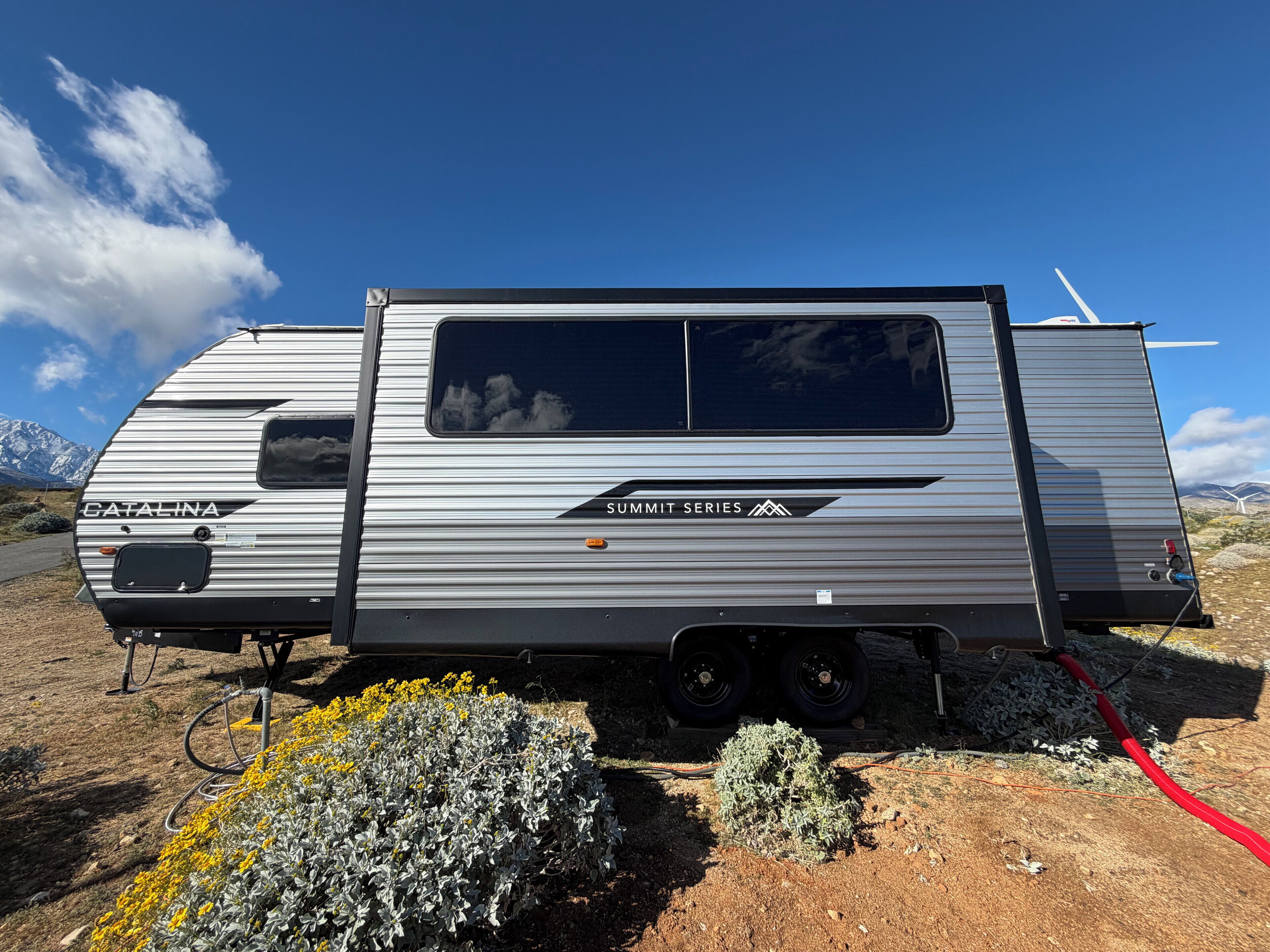 A Catalina Summit Series RV parked in a natural setting with mountains in the background.