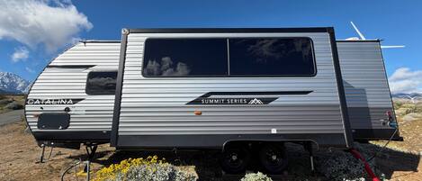 A Catalina Summit Series RV parked in a natural setting with mountains in the background.