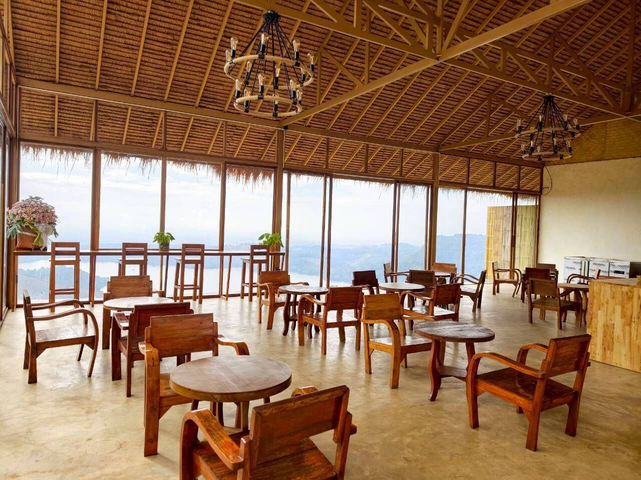 Amplio espacio interior con mobiliario de madera y grandes ventanales que ofrecen vistas a las montañas.