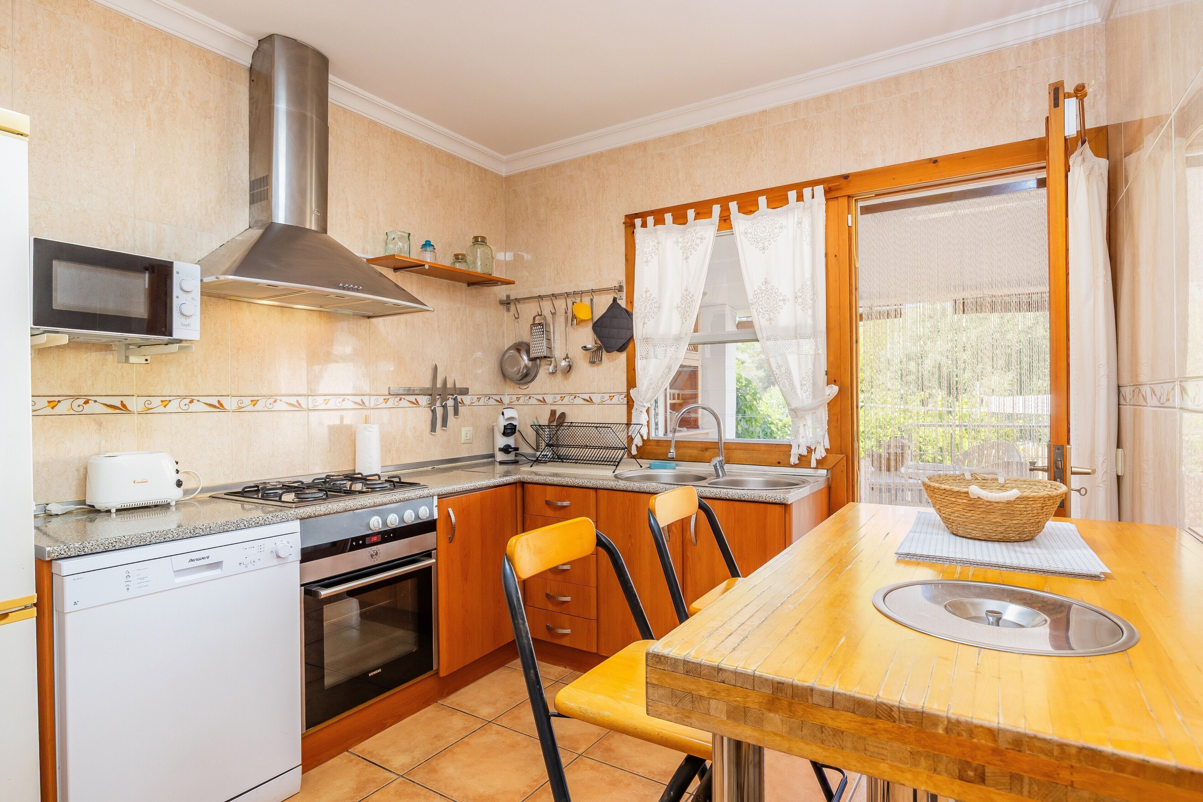 Una cocina compacta con microondas, estufa, horno y lavamanos.