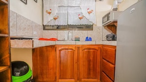 A kitchen with wooden cabinets, a microwave, a toaster, and a sink. - #1Apartment Colibri & A/C Fully furnish (Zeta trece)
