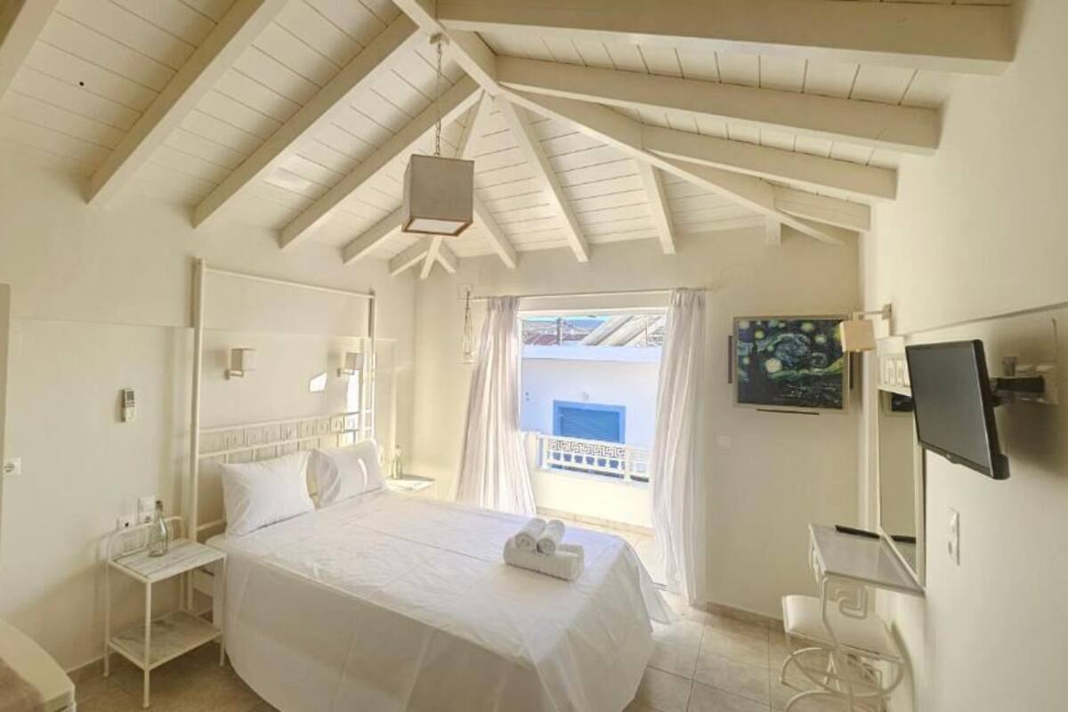 A bedroom with a bed, bedside table, and a TV.