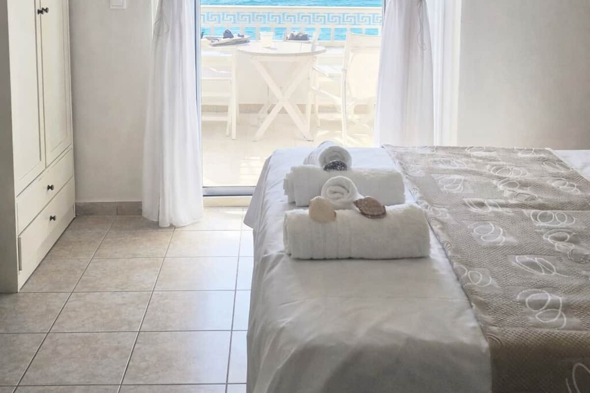 A hotel room with a bed, a wardrobe, and a view of the sea.