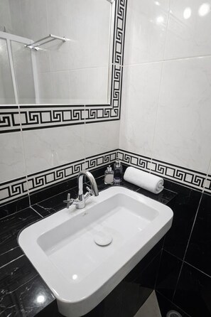 Habitación triple Deluxe, balcón, vista al mar | Baño | Amenidades de baño gratuitas, secadora de cabello, toallas, jabón 