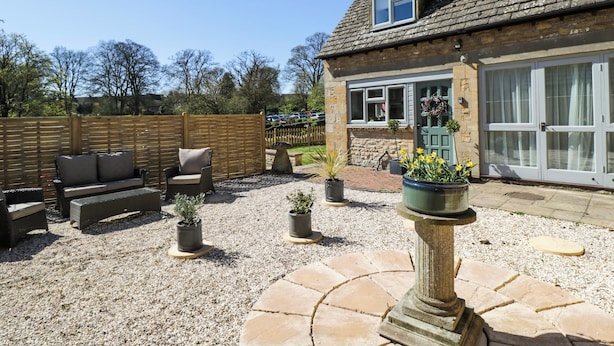 A house with a patio area, outdoor seating, and potted plants. - Paddock View (Cheltenham)