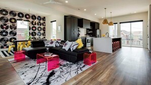 A modern living space with a black sofa, red accent chairs, and a record wall. - House of Rock! Ping Pong - 6 beds. Lux home! (Nashville)