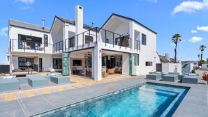 A modern two-story house with a swimming pool, outdoor seating, and a patio area. - C’est La Vie Beach Villa (Saint Helena Bay)