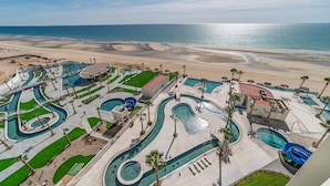 Un resort con varias piscinas, una playa y vistas al océano.