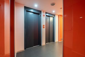 A modern elevator area with four elevators, each marked with a number. - Modern Flat with Balcony & Garage by HostWise (Porto)