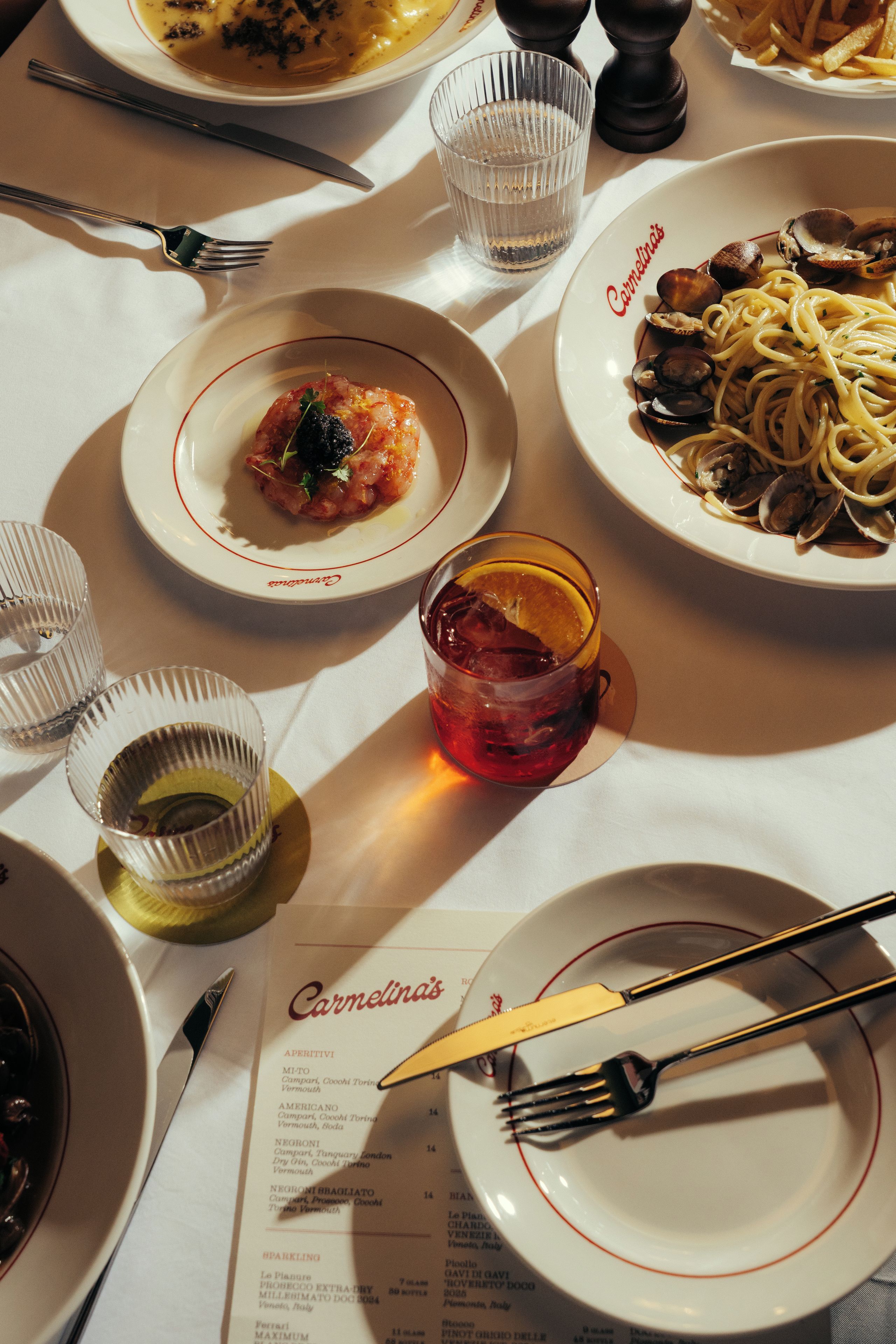 A table set with various dishes, a menu, and cutlery.