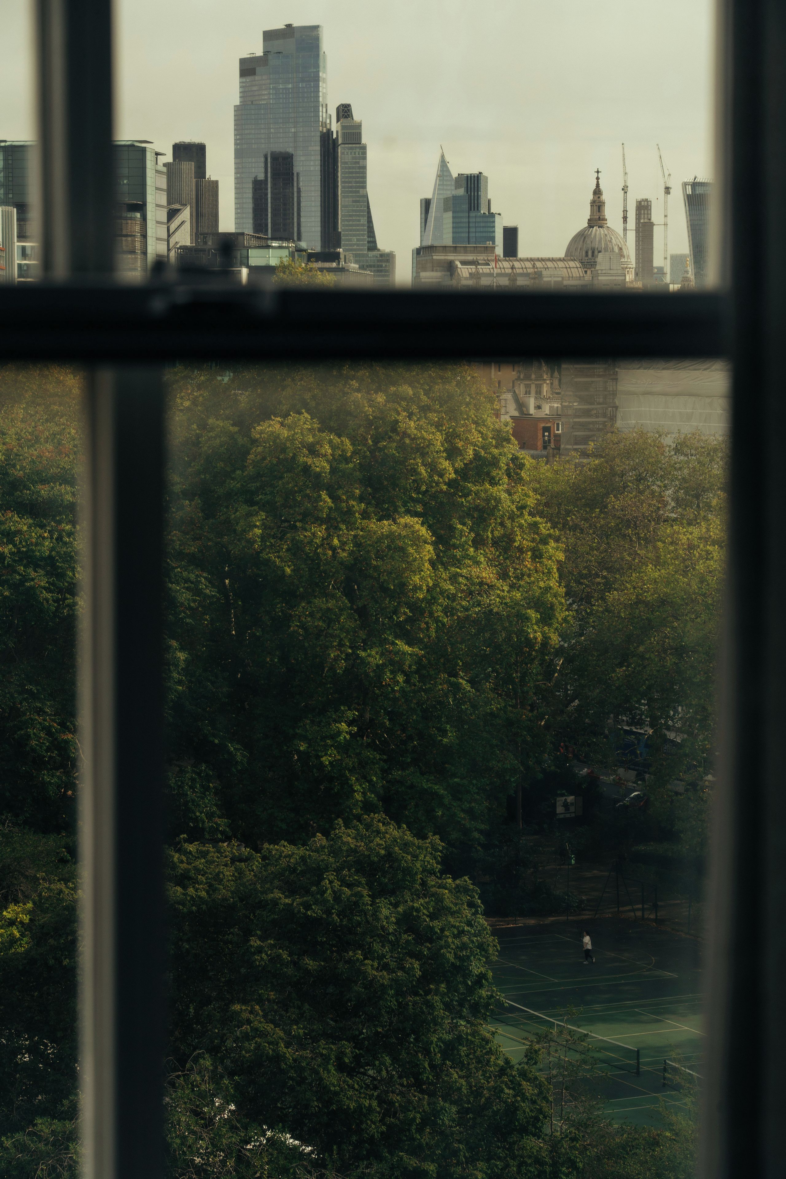 A view of a cityscape with modern buildings and a park area.