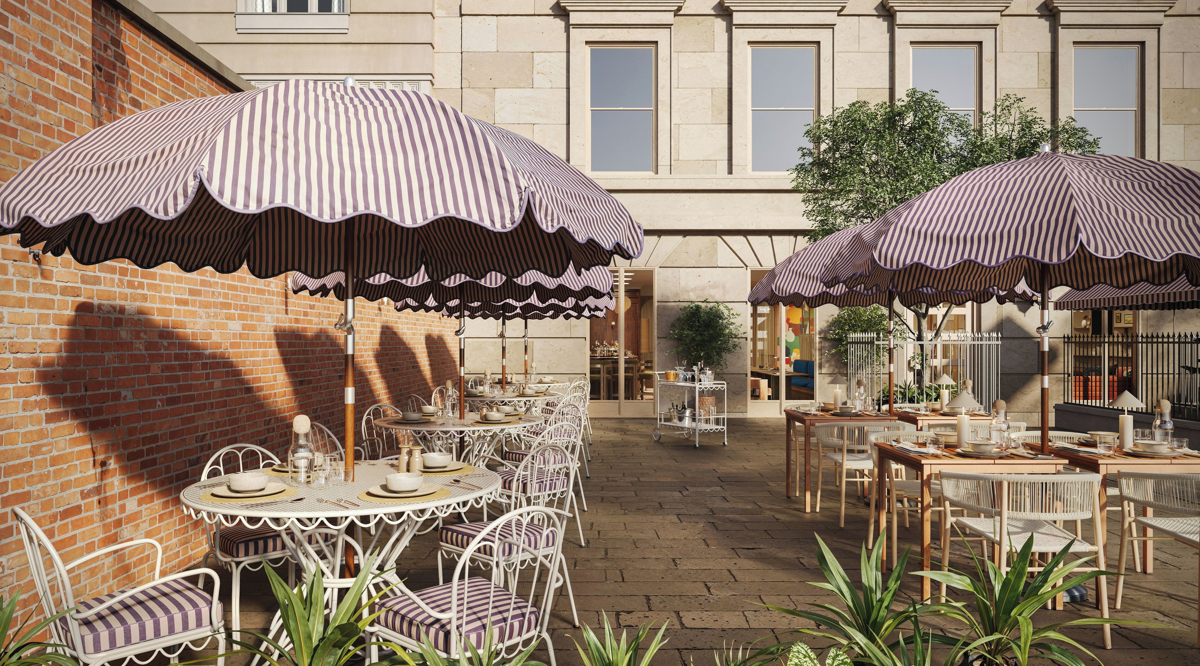 An outdoor patio with tables and chairs, striped umbrellas, and a brick wall.