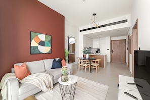 A modern living room with a sofa, coffee table, and artwork on the wall. - Silkhaus Cozy 1bdr Binghatti Tulip JVC (Dubai)