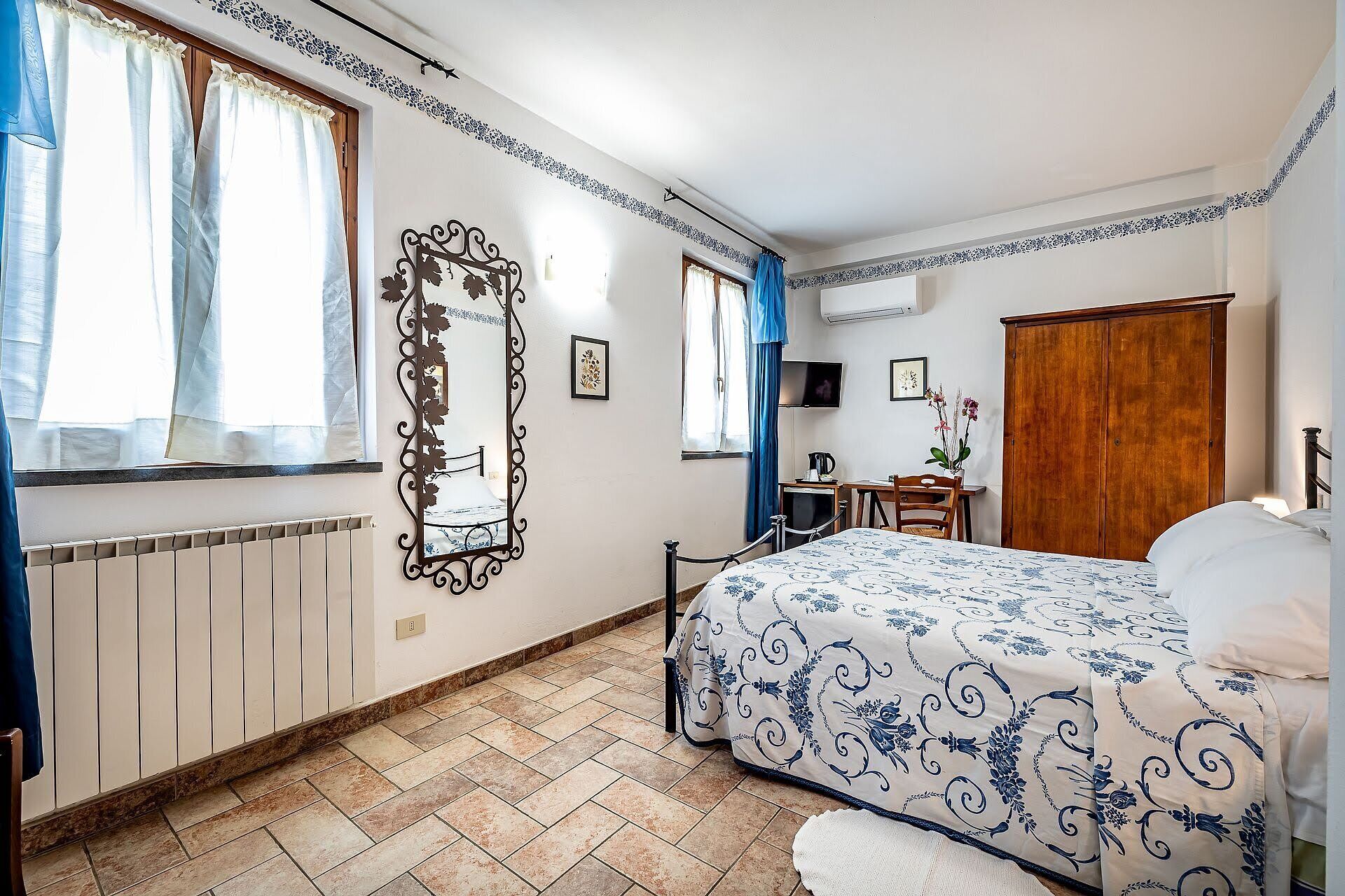 Un dormitorio con cama, escritorio, silla, armario y radiador.