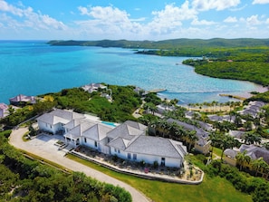 A resort with multiple buildings, a swimming pool, and a view of the ocean. - Brand new luxury 5-bedroom villa on resort (FreeTown)