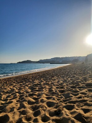 A beach with a clear sky and the sun shining. - A 2-minute walk from Albufeira beach and 5 minutes from the historic center! (Albufeira)