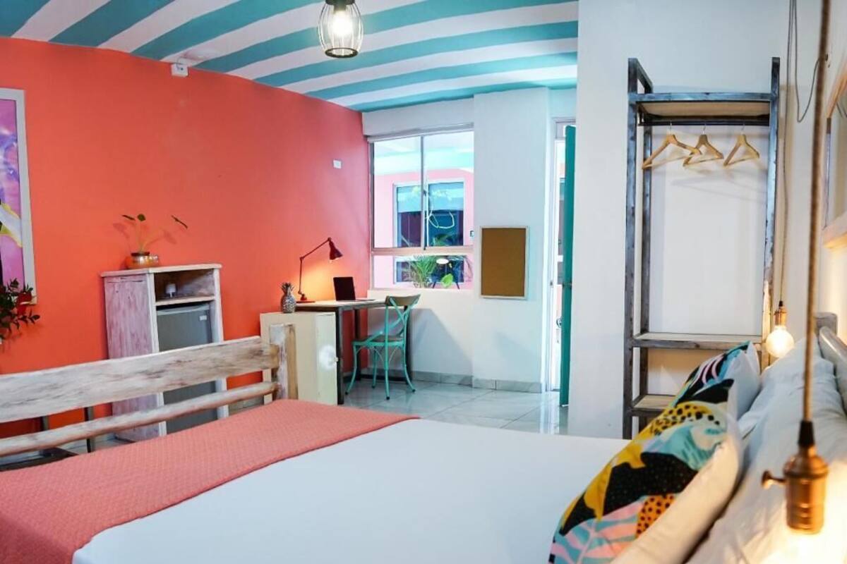 A room with a bed, a desk, a chair, and a window.