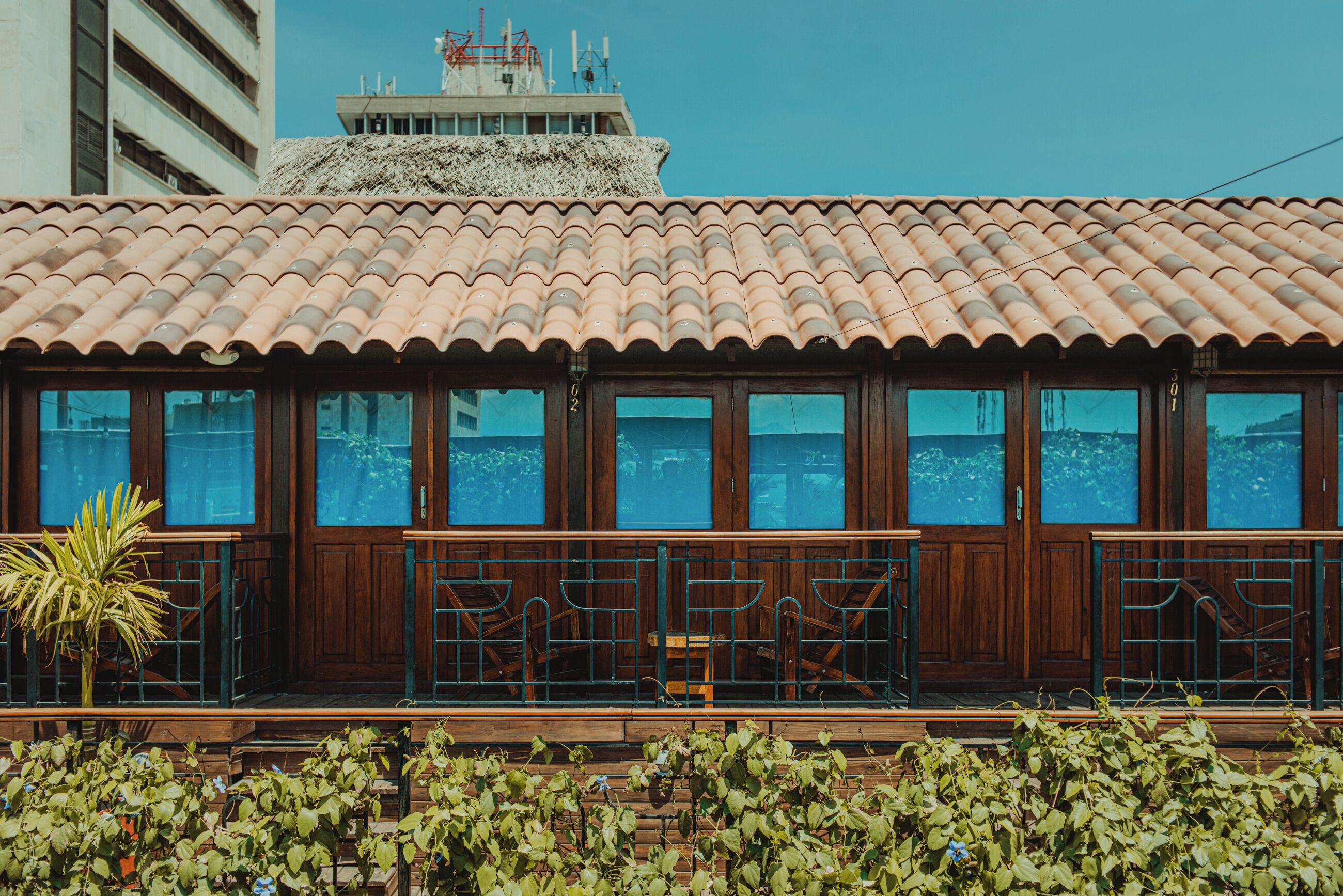 A building with a tiled roof, large windows, and a balcony with railings.