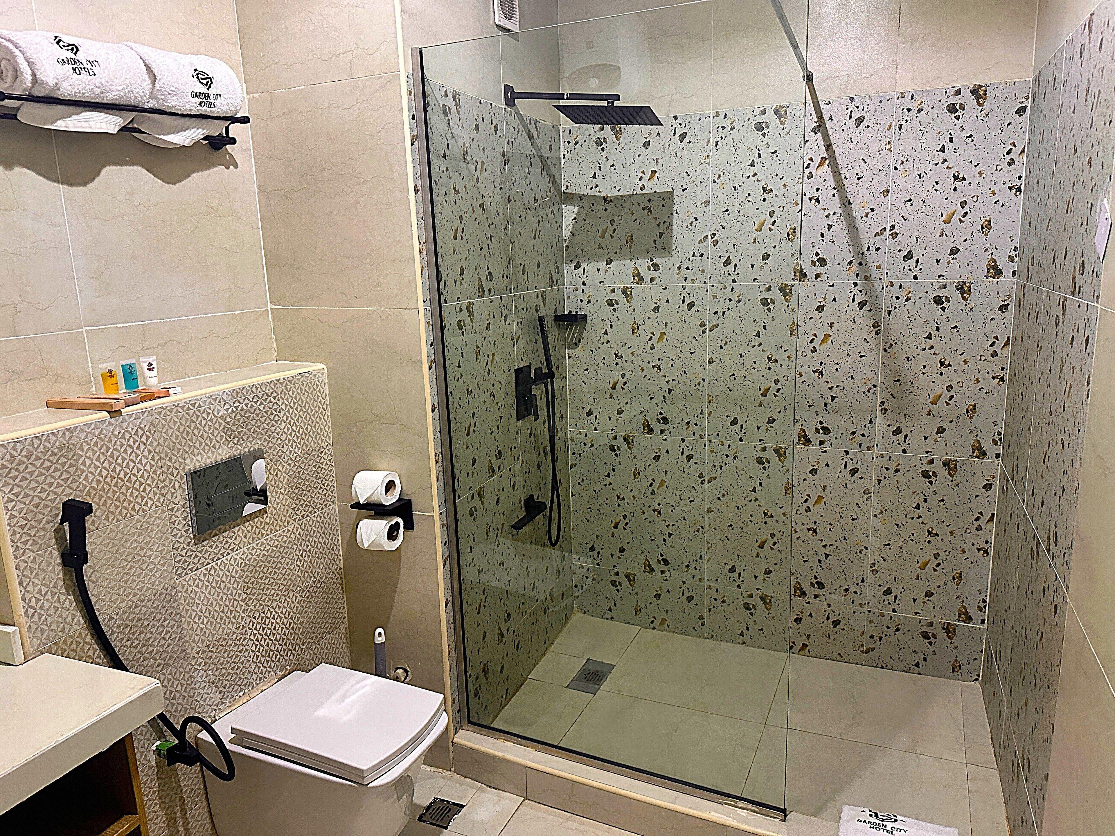Un baño con ducha de vidrio, inodoro y lavamanos.