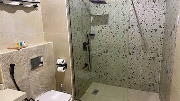 Un baño con ducha de vidrio, inodoro y lavamanos.