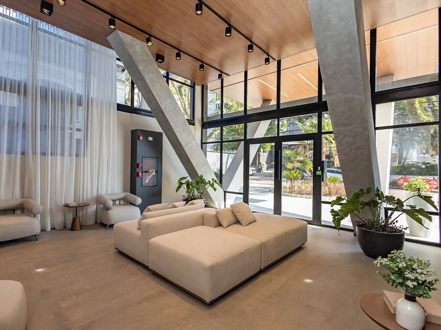 A modern interior with a sectional sofa, a small table, and potted plants.