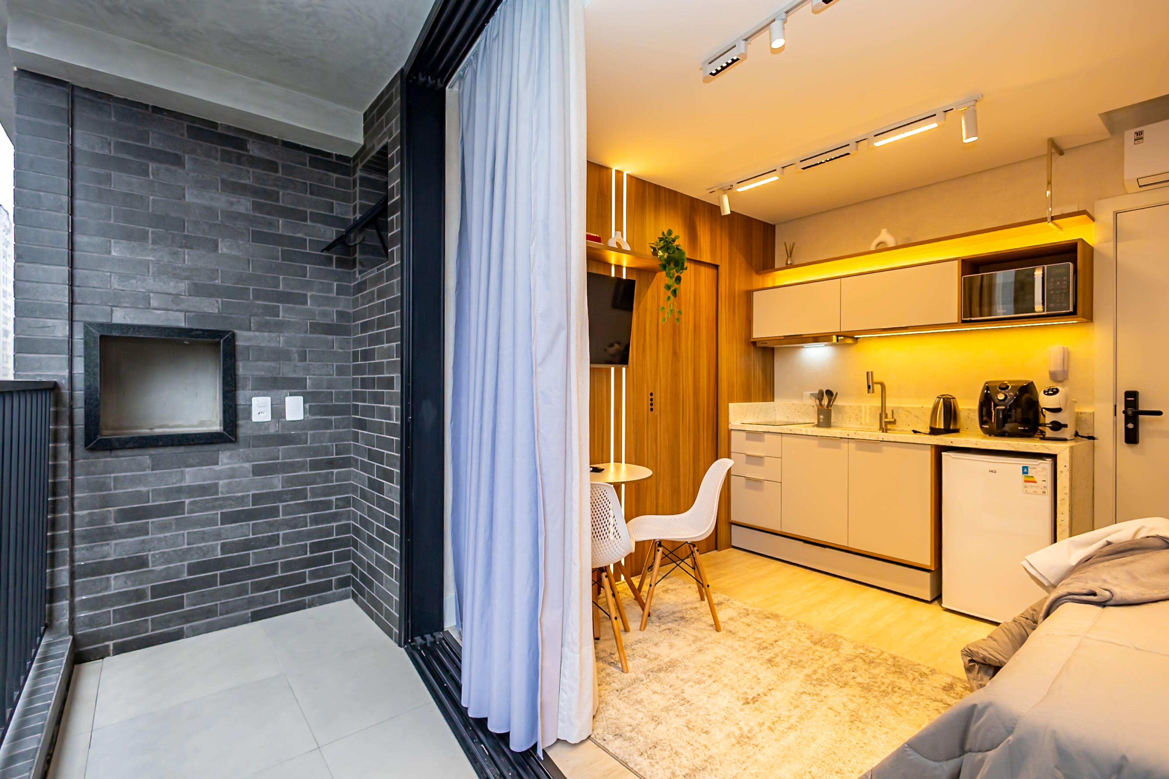 Una cocina moderna con microondas, cafetera y refrigerador pequeño.