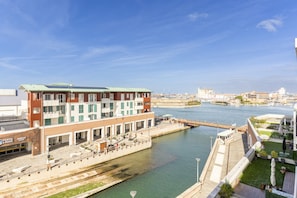 A waterfront building with a green roof, a dock, and a clear view of the water.