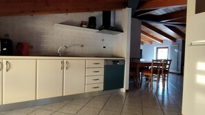 Una cocina con armarios blancos, lavavajillas y piso de baldosas.