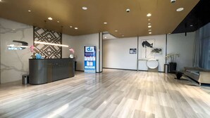 A spacious lobby with a reception desk, a digital information board, and a seating area with a sofa and a coffee table. - Stayshort - 1 Bed in Business Bay That Sleeps 4 Perfect for Everyone (Dubai)