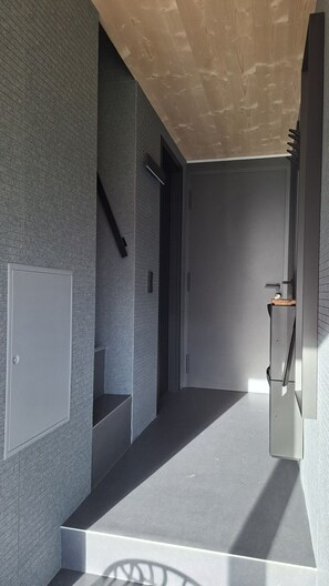 A modern interior with a staircase, a door, and a wall-mounted cabinet.