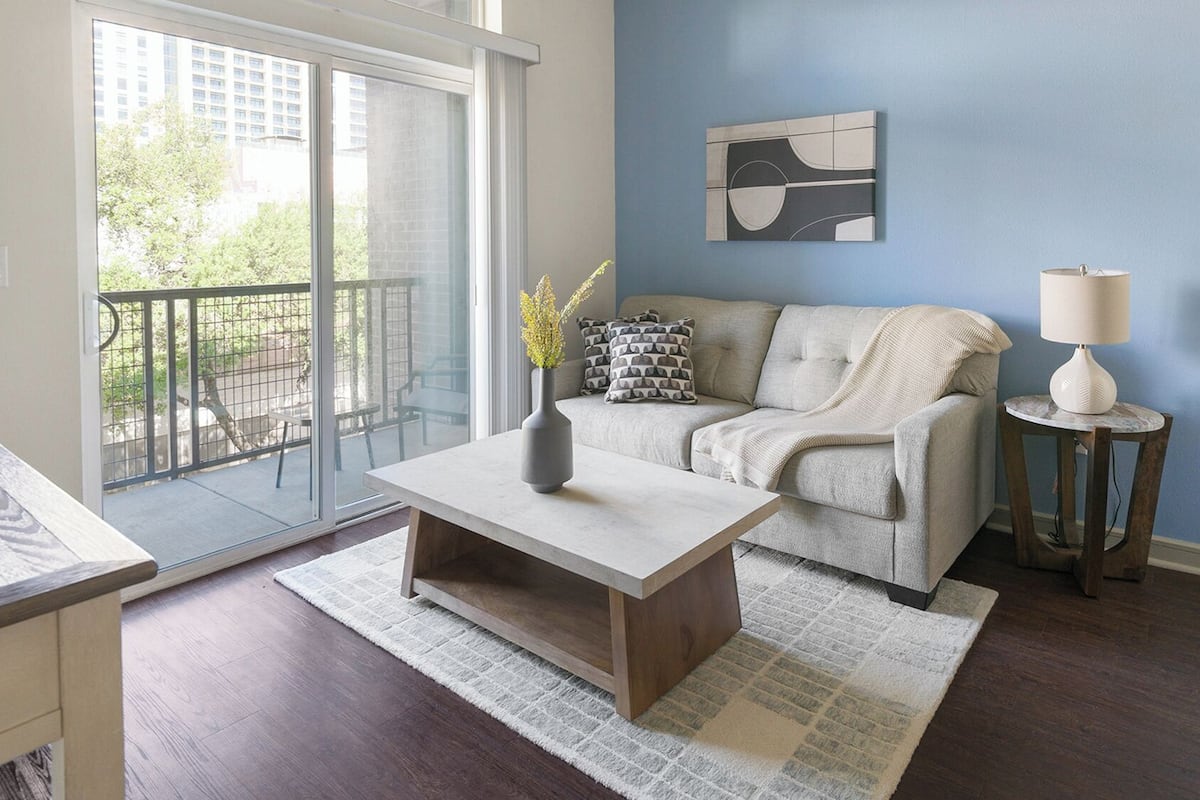 A modern living room with a sofa, coffee table, and a lamp.