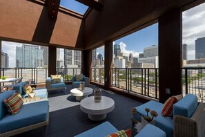 Eine Dachterrasse mit Sitzgelegenheiten und Blick auf die Stadtlandschaft.